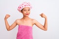 Young chinese woman wearing shower towel and cap bath over isolated white background showing arms muscles smiling proud Royalty Free Stock Photo