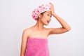 Young chinese woman wearing shower towel and cap bath over isolated white background surprised with hand on head for mistake, Royalty Free Stock Photo