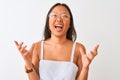 Young chinese woman wearing striped dress and glasses over isolated white background crazy and mad shouting and yelling with Royalty Free Stock Photo