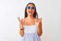 Young chinese woman wearing striped dress and sunglasses over isolated white background crazy and mad shouting and yelling with Royalty Free Stock Photo