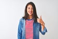 Young chinese woman wearing striped t-shirt and denim shirt over isolated white background doing happy thumbs up gesture with hand Royalty Free Stock Photo