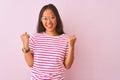 Young chinese woman wearing striped t-shirt and glasses over isolated pink background very happy and excited doing winner gesture Royalty Free Stock Photo