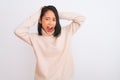 Young chinese woman wearing turtleneck sweater standing over isolated white background Crazy and scared with hands on head, afraid Royalty Free Stock Photo