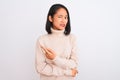 Young chinese woman wearing turtleneck sweater standing over isolated white background Pointing aside worried and nervous with Royalty Free Stock Photo
