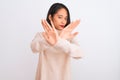 Young chinese woman wearing turtleneck sweater standing over isolated white background Rejection expression crossing arms and Royalty Free Stock Photo