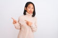 Young chinese woman wearing turtleneck sweater standing over  white background Pointing aside worried and nervous with Royalty Free Stock Photo