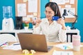 Young chinese woman working at the office doing online shopping smiling with an idea or question pointing finger with happy face, Royalty Free Stock Photo