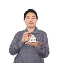 Young Chinese worker in overalls holding a small house model Royalty Free Stock Photo