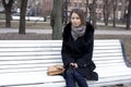 young city woman sits on a bench