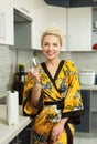 Young clapboard in the kitchen with a pack of healthy natural juice drinks from a glass