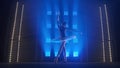 Young classical ballet dancer dancing in background of smoke and spotlights with soft blue light. Silhouette of