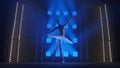 Young classical ballet dancer dancing in background of smoke and spotlights with soft blue light. Silhouette of