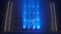 Young classical ballet dancer dancing in background of smoke and spotlights with soft blue light. Silhouette of Royalty Free Stock Photo