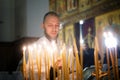 A young clergyman lights candles near the altar of a Christian Orthodox church. December 31, 2019. Russia, Magnitogorsk Royalty Free Stock Photo