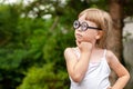 Young clever intelligent school age child, little girl in big quirky glasses thinking, wondering, deep in thought, copy space