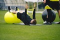 Young Coach Showing to Junior Players How to Exercise Properly on Training Mat and Training Yoga Ball