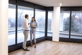 Young colleagues having a conversation during the coffee break while standing near the window Royalty Free Stock Photo