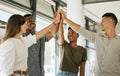 Young colleagues standing in office raising hands to give high five during team building. Diverse business team standing Royalty Free Stock Photo