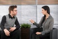 Young colleagues talking in office lobby