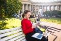 Young college female in casual wear sending sms via mobile phone Royalty Free Stock Photo