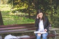 Young college or school girl feeling sick with strong headache pain or migraine attack while she sitting on the bench in the park Royalty Free Stock Photo