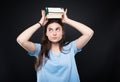 Young college student holding stack of books on head Royalty Free Stock Photo