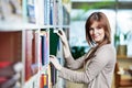 Young student selecting book in library