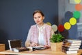 Young college woman sitting at table in campus cafe reading new book series