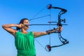 Young colombian woman aims arrow of compound bow Royalty Free Stock Photo