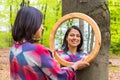 Woman looking at mirror in spring forest Royalty Free Stock Photo