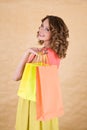 Young colorful dressed woman with color shopping bag