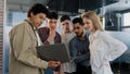 Young company employee explains development strategy tells new ideas showing work plan on laptop to smiling diverse Royalty Free Stock Photo