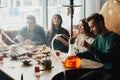 Young company is having fun and eating in bar. smoking a hookah, communicating in an oriental restaurant. Royalty Free Stock Photo