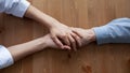 Young compassionate female nurse holding hand of old patient. Royalty Free Stock Photo