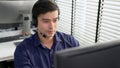 Young competent asian male call center agent working in the office. Royalty Free Stock Photo