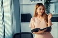 Young competent office lady, intern, secretary holding a log in office room.