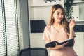 Young competent office lady, intern, secretary holding a log in office room.