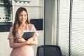 Young competent office lady, intern, secretary holding a log in office room.