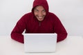 A young computer geek working online. Hacker wearing a hooded to