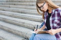 Young student girl making notes in notebook Royalty Free Stock Photo