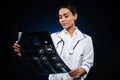 Young concentrated lady looking at x-ray image isolated