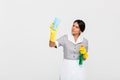 Young concentrated maid in uniform cleaning window with rag