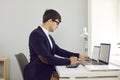 Young concentrated male business financier working with spreadsheets using two laptops.