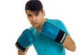 Young concentrated man in blue shirt practicing boxing in gloves isolated on white background Royalty Free Stock Photo