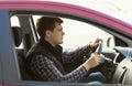 Young concentrated man driving a car