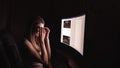 Young concentrated woman, sitting in her room or office .Studies late at night.Staying up late. Woman feeling headache Royalty Free Stock Photo