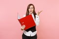 Young concerned business woman in suit, glasses holding red folder for papers document spreading hands on pink Royalty Free Stock Photo