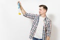 Young concerned handsome man in casual clothes holding paint roller for wall painting isolated on white background Royalty Free Stock Photo