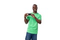 young confident american male advertiser dressed in green mockup t-shirt holding credit card