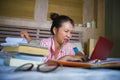 Young confident and beautiful Asian Korean student girl preparing University exam studying at home bedroom with laptop computer Royalty Free Stock Photo